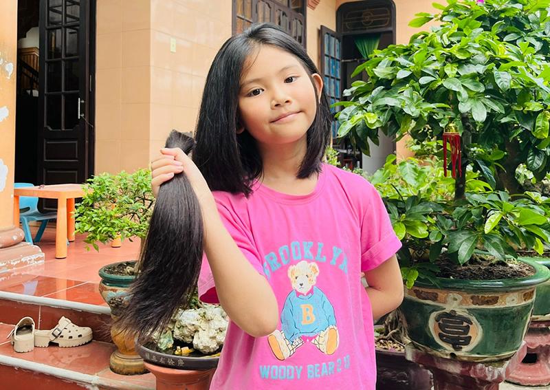 Bé gái cười tươi, tự tin với mái tóc tém của mình trong khung cảnh vui vẻ